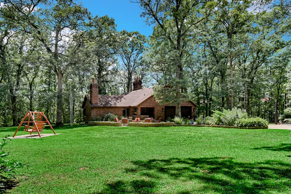a front view of a house with yard and trees