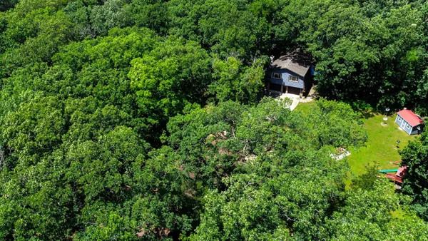 an aerial view of a residential houses with yard