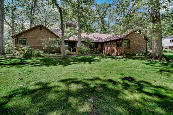 a front view of a house with a garden and trees