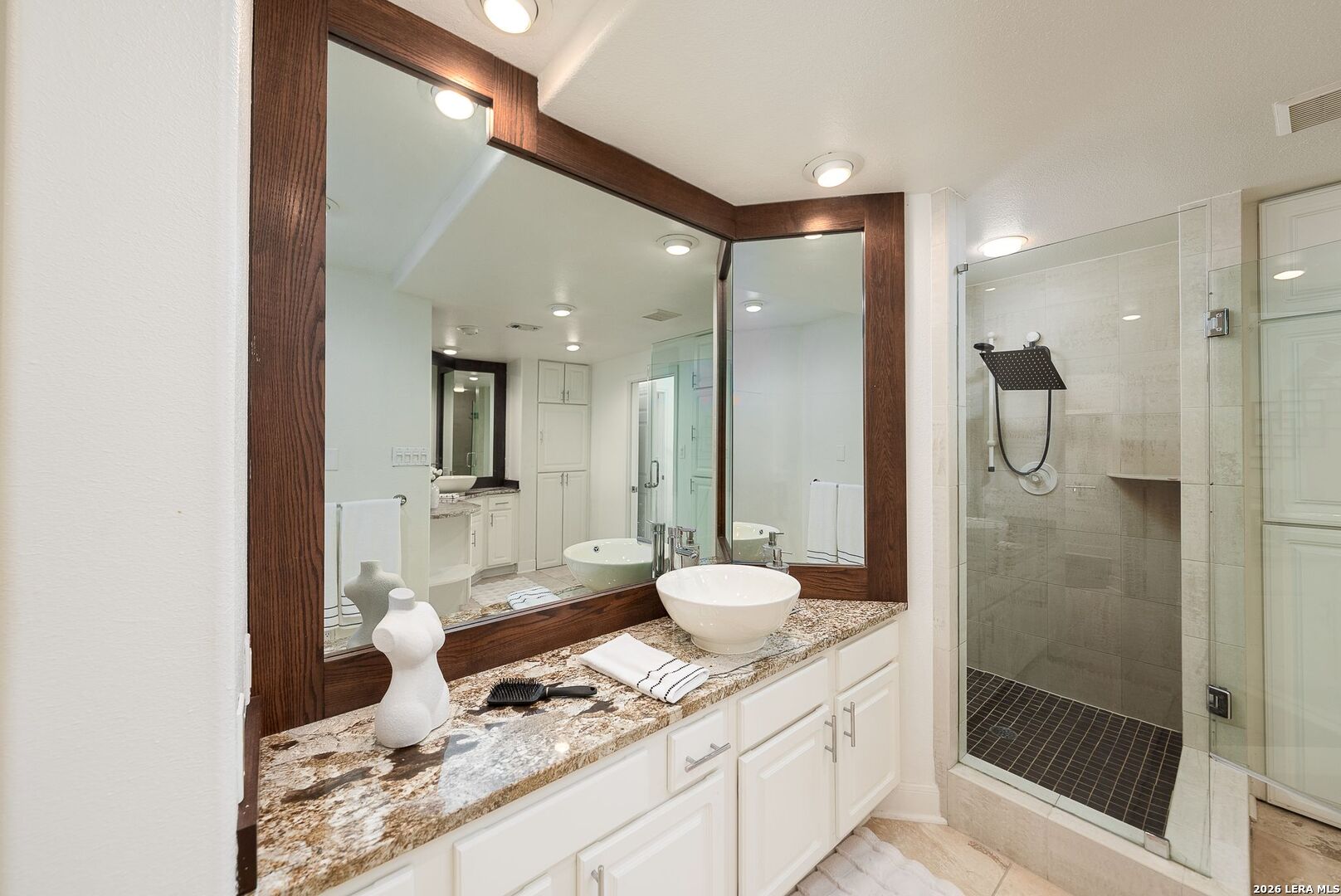 7701 Wurzbach Road, Unit 2302 San Antonio, TX 78229 - Photo 19 of 49 a spacious bathroom with a granite countertop sink mirror and shower