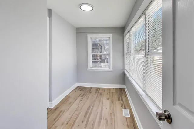 a view of a room with wooden floor and windows