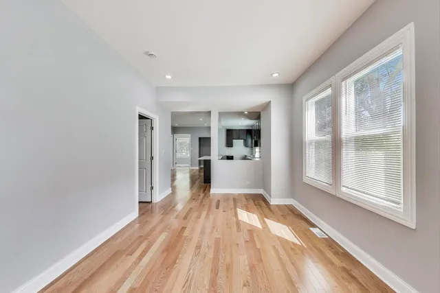 a view of a living room hardwood floor and a kitchen