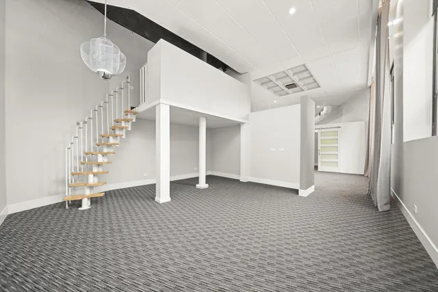 a view of an empty room with wooden floor and a large window