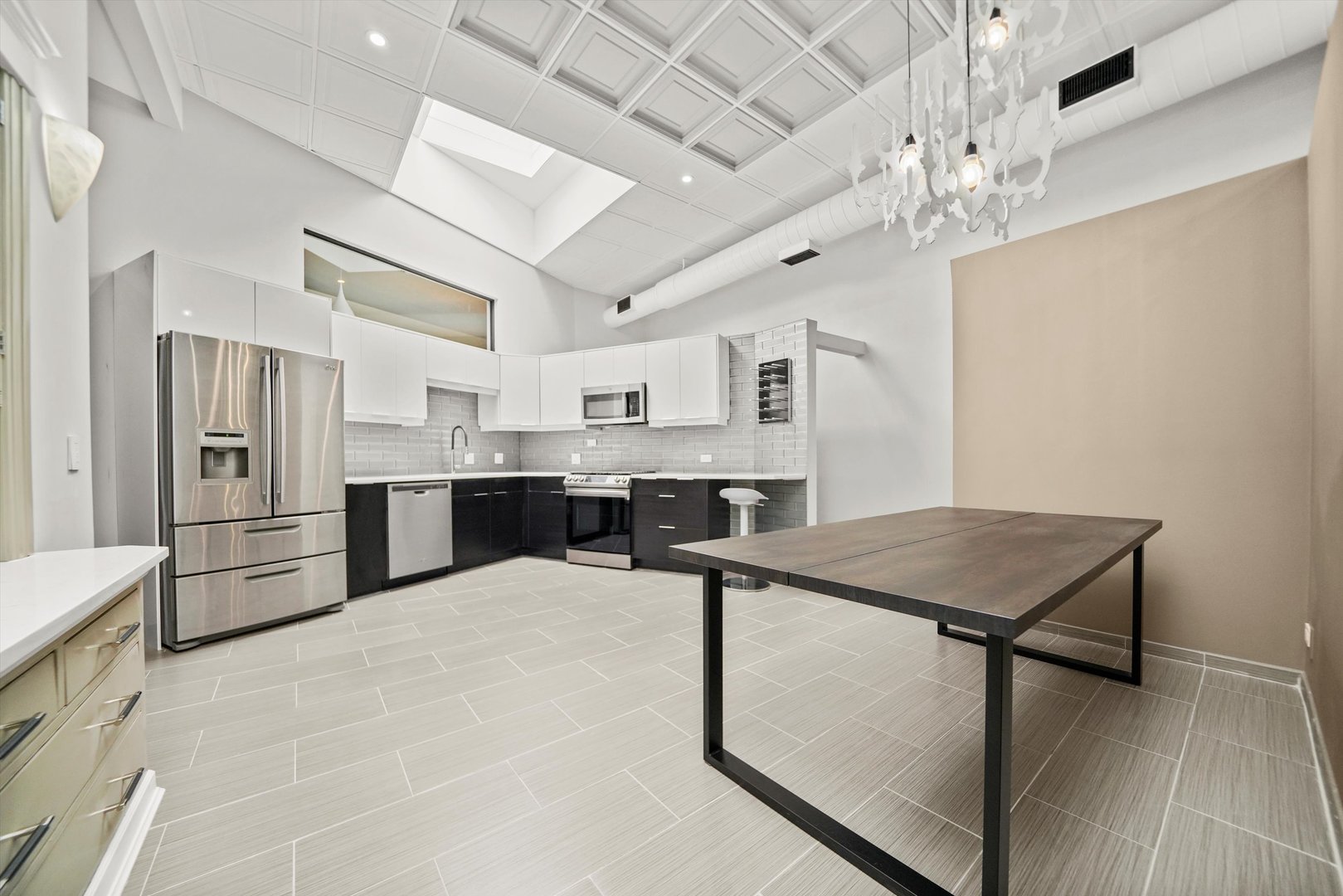 300 North Ogden Avenue, Unit 202 Chicago, IL 60607 - Photo 3 of 25 a kitchen with stainless steel appliances kitchen island a table chairs refrigerator and microwave