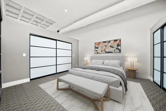 a bedroom with a bed a rug and wooden floor