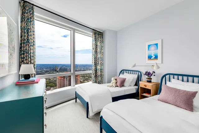 a bedroom with two beds and large window