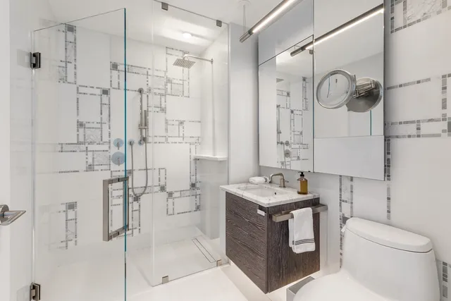 a bathroom with a granite countertop sink a toilet and shower