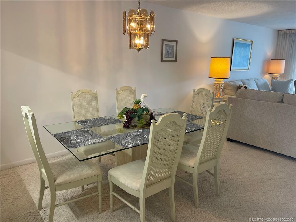 1858 Southwest Palm City Road, Unit 203 Stuart, FL 34994 - Photo 12 of 21 a dining room with furniture and chandelier