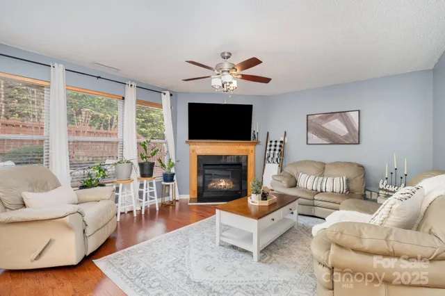 a living room with furniture a fireplace and a flat screen tv