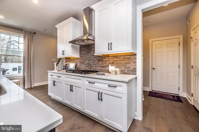 a kitchen with stainless steel appliances granite countertop a stove and a wooden floors