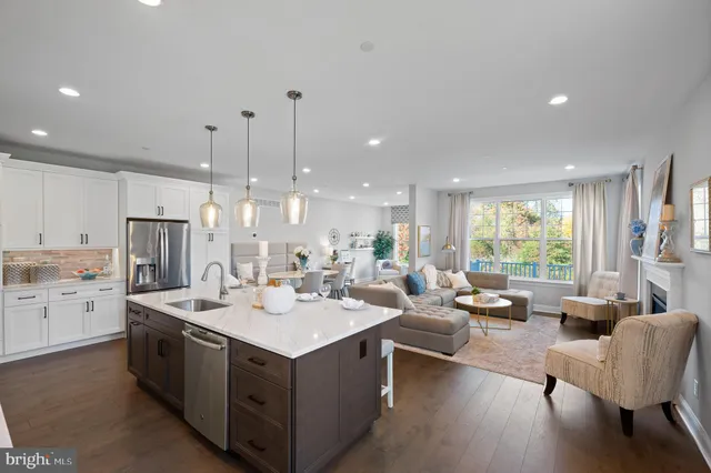 a large kitchen with kitchen island a sink a center island stainless steel appliances and a large window