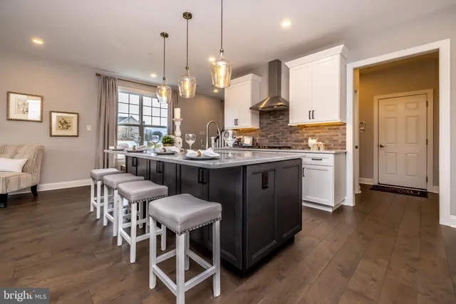a kitchen with a dining table chairs and white cabinets