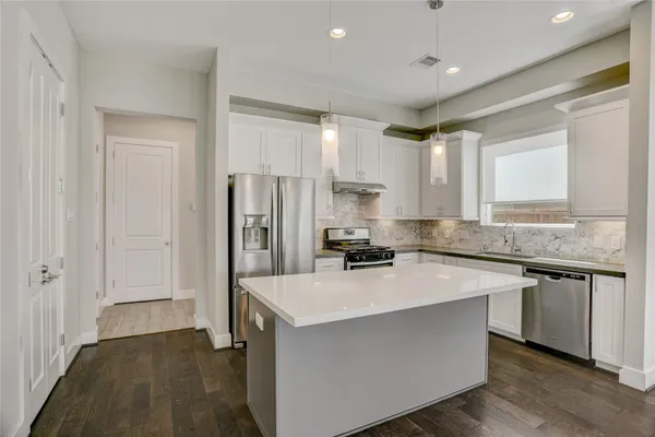 a open kitchen with stainless steel appliances granite countertop a sink and cabinets with wooden floor