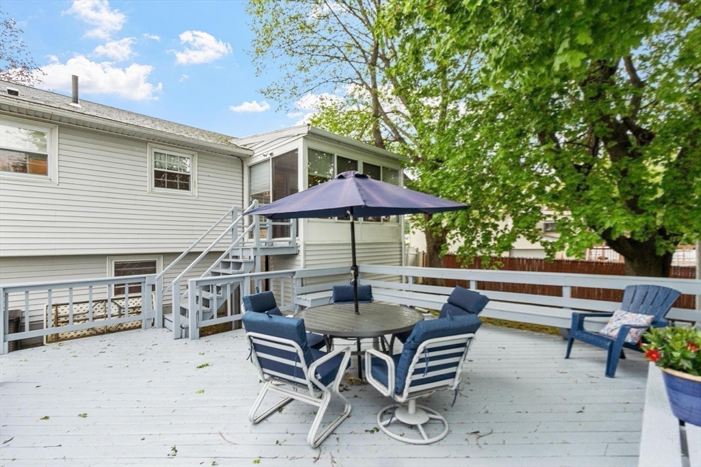 134 River Road Lowell, MA 01852 - Photo 30 of 36 a patio with a table and chairs under an umbrella