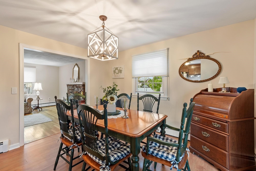 134 River Road Lowell, MA 01852 - Photo 9 of 36 a dining room with wooden floor a chandelier a glass table and chairs