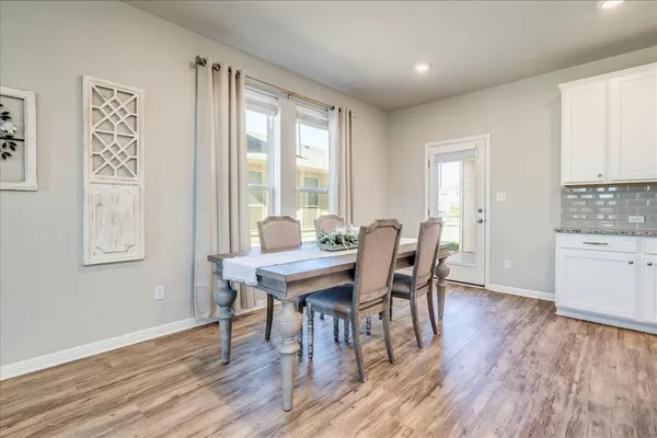 a view of a a dining room with furniture window and wooden floor