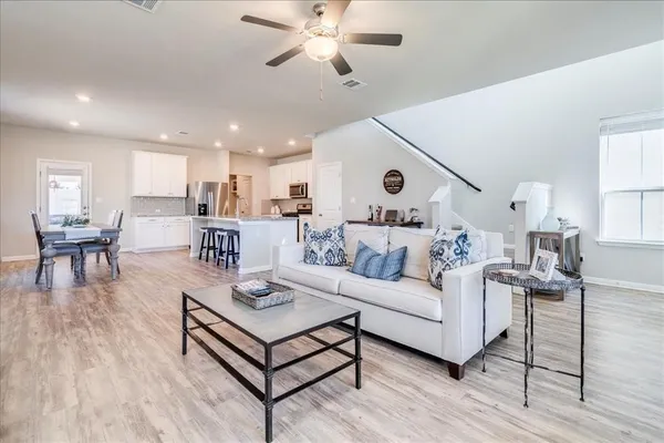 a living room with furniture and view of kitchen