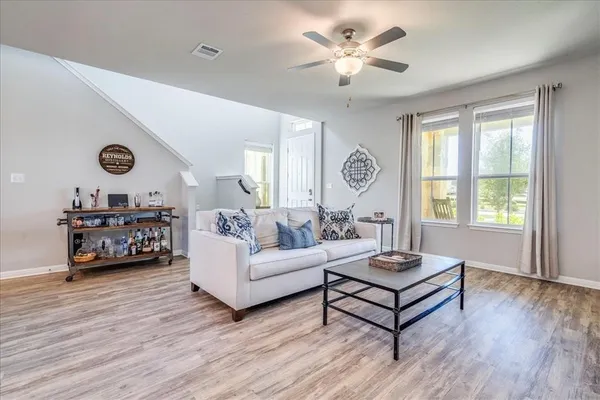 a living room with furniture a wooden floor and a large window