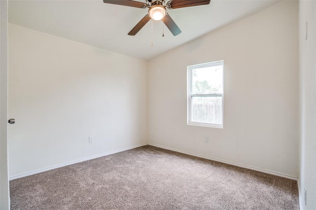 9695 Olive Street Princeton, TX 75407 - Photo 16 of 23 Empty room featuring carpet floors, baseboards, vaulted ceiling, and ceiling fan
