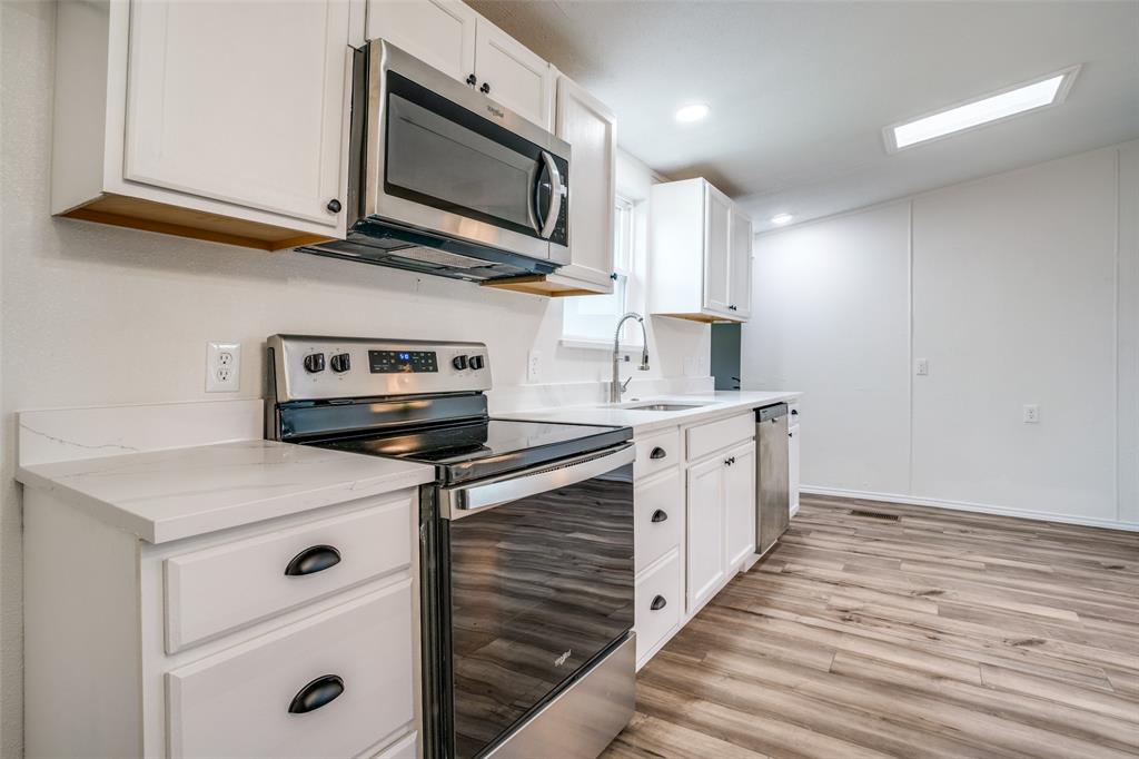 9695 Olive Street Princeton, TX 75407 - Photo 7 of 23 Kitchen featuring a sink, white cabinets, and appliances with stainless steel finishes