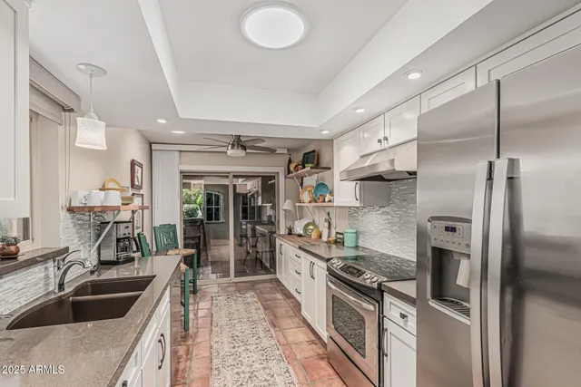 a front view of a house with a yard and potted plants