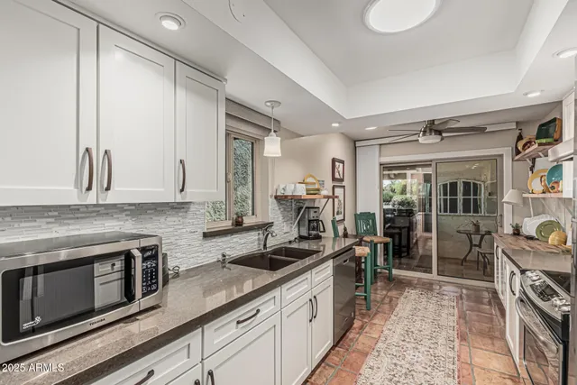 a kitchen with stainless steel appliances granite countertop a sink stove and cabinets