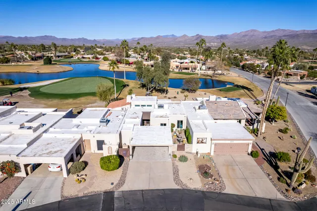 an aerial view of residential houses with outdoor space and lake view