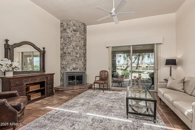 a living room with furniture a fireplace and a floor to ceiling window