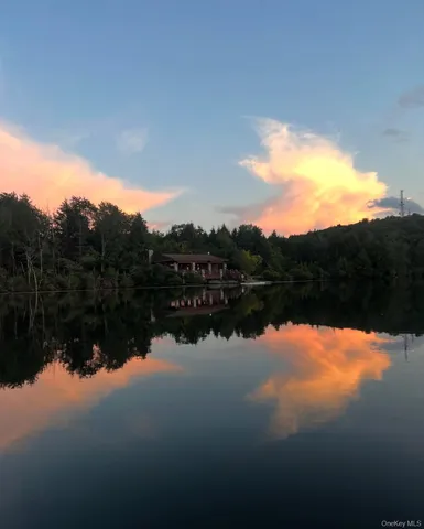 a view of a lake in front of house with outdoor seating