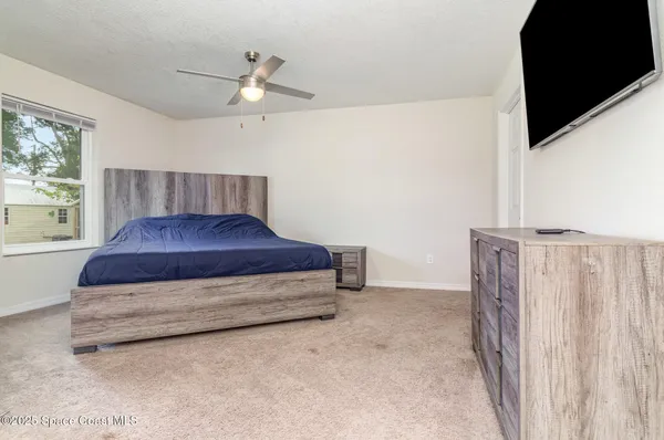 a spacious bedroom with a bed and a window