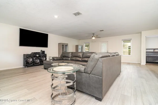 a kitchen with stainless steel appliances granite countertop a sink stove and white cabinets with wooden floor