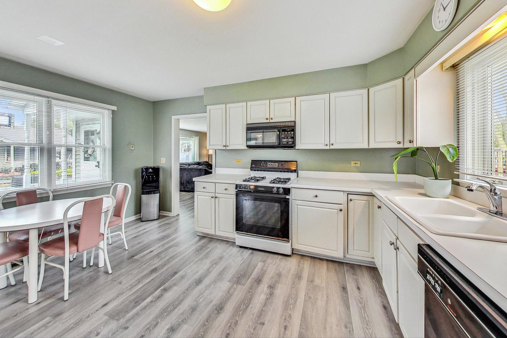1010 Aurora Way Wheaton, IL 60189 - Photo 11 of 37 a kitchen with a sink white cabinets and white appliances