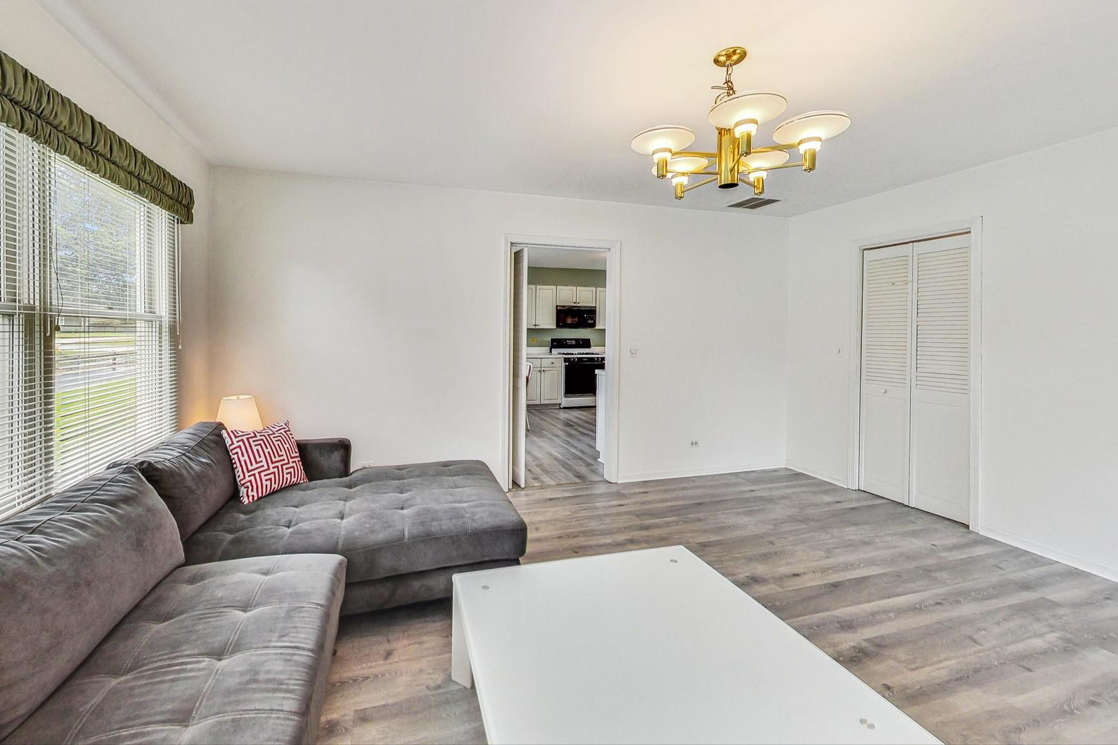 1010 Aurora Way Wheaton, IL 60189 - Photo 14 of 37 a living room with couches painting on the wall and a window