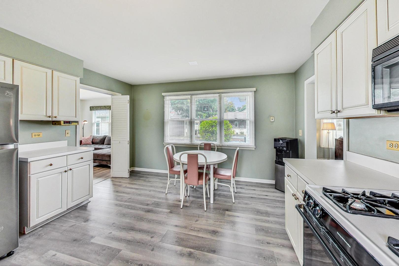 1010 Aurora Way Wheaton, IL 60189 - Photo 10 of 37 a kitchen with stainless steel appliances granite countertop a stove top oven a sink dishwasher and white cabinets with wooden floor