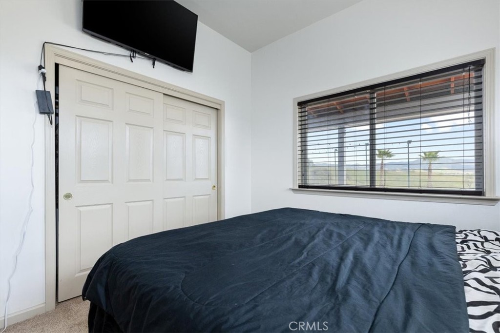 67911 Jolon Road Lockwood, CA 93932 - Photo 20 of 29 a bedroom with a bed and a flat tv screen on the dresser