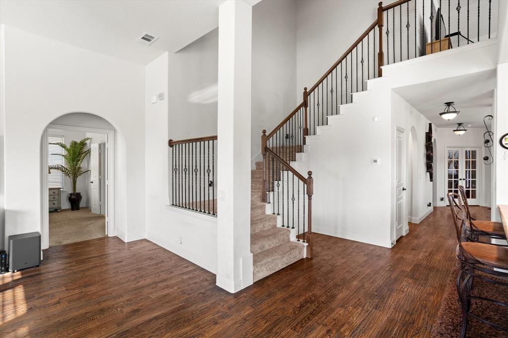 1814 Chadwick Lane Forney, TX 75126 - Photo 28 of 40 Entryway featuring arched walkways, a high ceiling, wood finished floors, and stairway