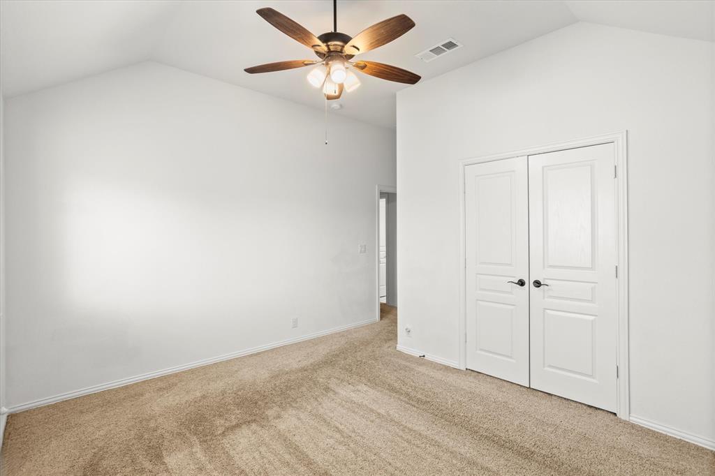 1814 Chadwick Lane Forney, TX 75126 - Photo 33 of 40 Unfurnished bedroom with vaulted ceiling, carpet floors, a closet, and a ceiling fan
