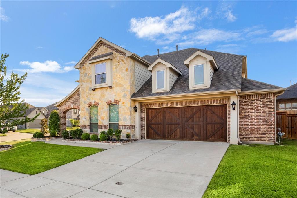 1814 Chadwick Lane Forney, TX 75126 - Photo 5 of 40 View of front of property with roof with shingles, stone siding, a garage, and driveway