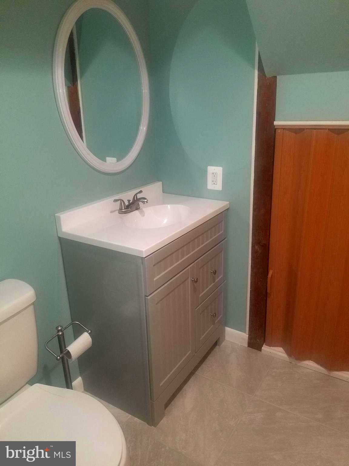 1631 Riverwood Road Baltimore, MD 21221 - Photo 22 of 32 a bathroom with a toilet sink and mirror