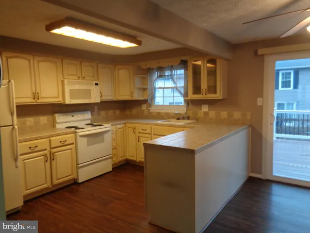 a kitchen with granite countertop white cabinets and white appliances