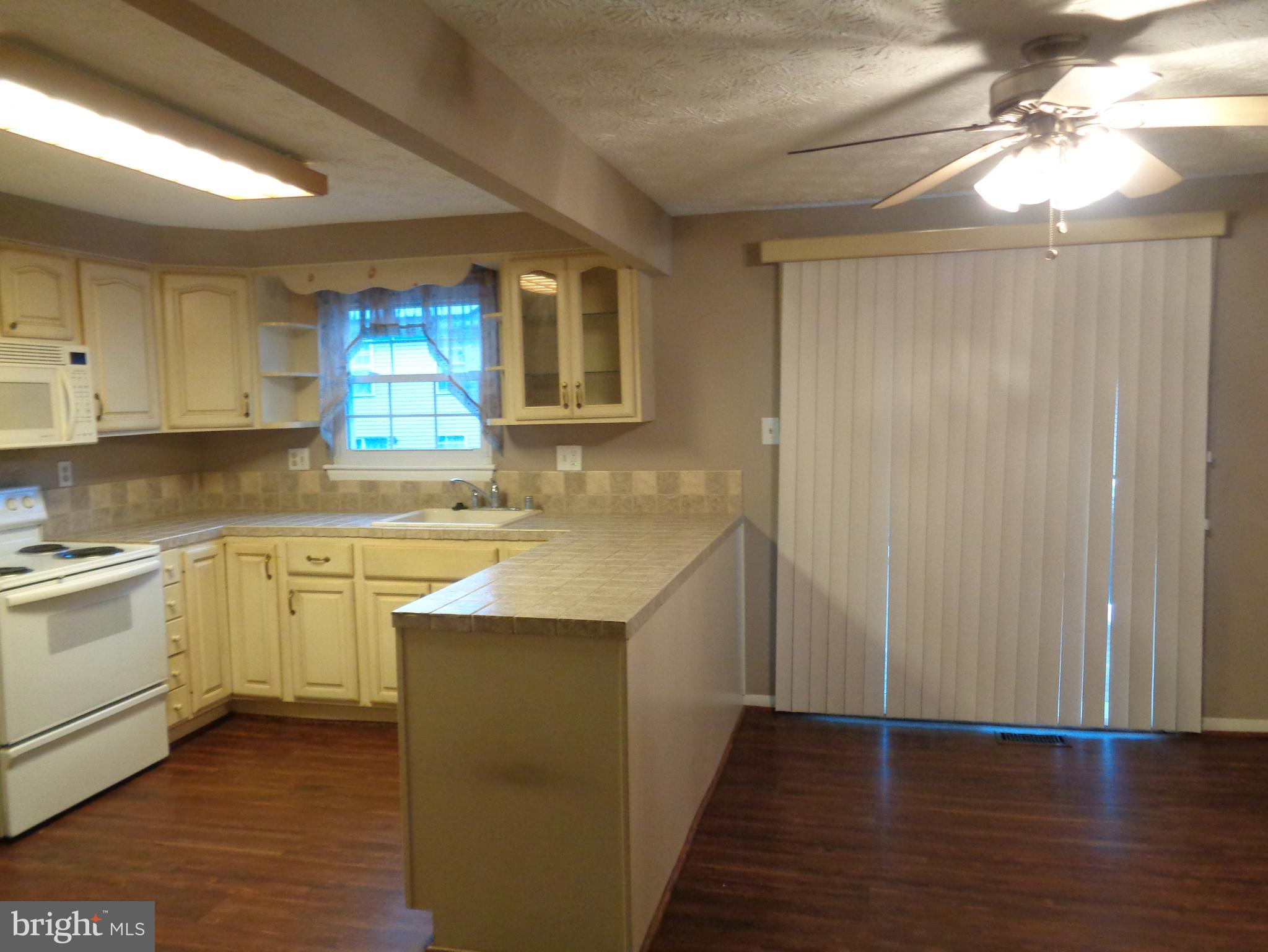 4020 Rustico Road Middle River, MD 21220 - Photo 13 of 59 a kitchen with granite countertop white cabinets and white appliances