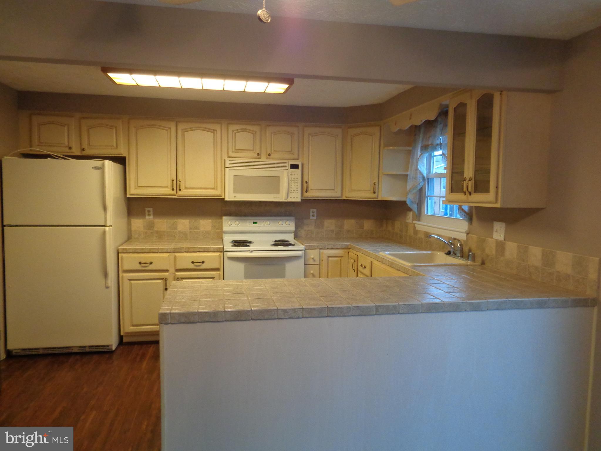 4020 Rustico Road Middle River, MD 21220 - Photo 14 of 59 a kitchen with stainless steel appliances granite countertop a refrigerator a stove a sink and a granite counter tops with wooden floors