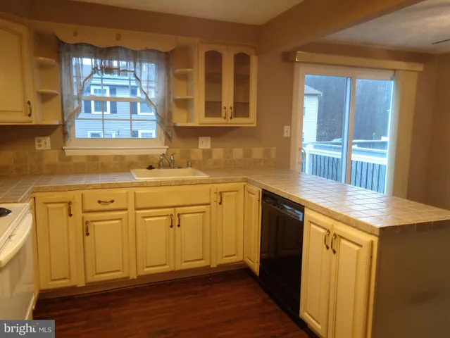 a kitchen with granite countertop white cabinets and white appliances