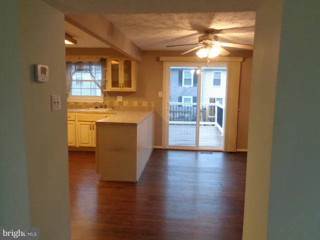 a kitchen with a white cabinets and wooden floor