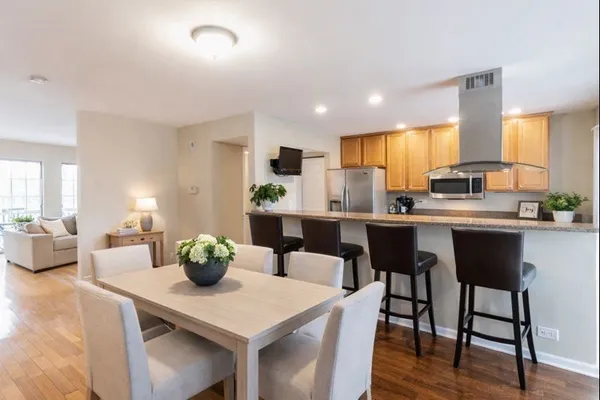 a kitchen with a table chairs and white cabinets