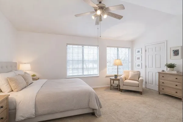 a bedroom with a bed chandelier and window