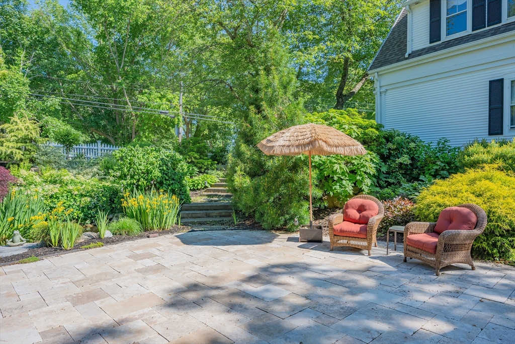 436 South Main Street Barnstable, MA 02632 - Photo 35 of 42 a backyard of a house with table and chairs under an umbrella