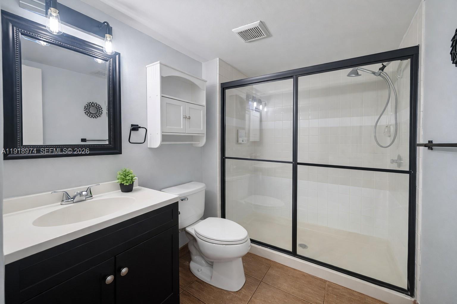 8801 Wiles Road, Unit 307 Coral Springs, FL 33067 - Photo 10 of 18 a bathroom with a toilet a sink and a mirror