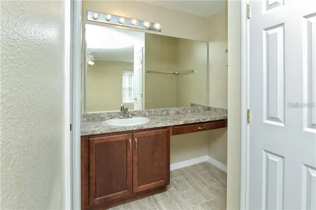 a bathroom with a granite countertop sink and a mirror