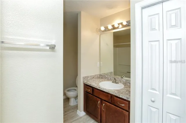 a bathroom with a granite countertop sink toilet and shower